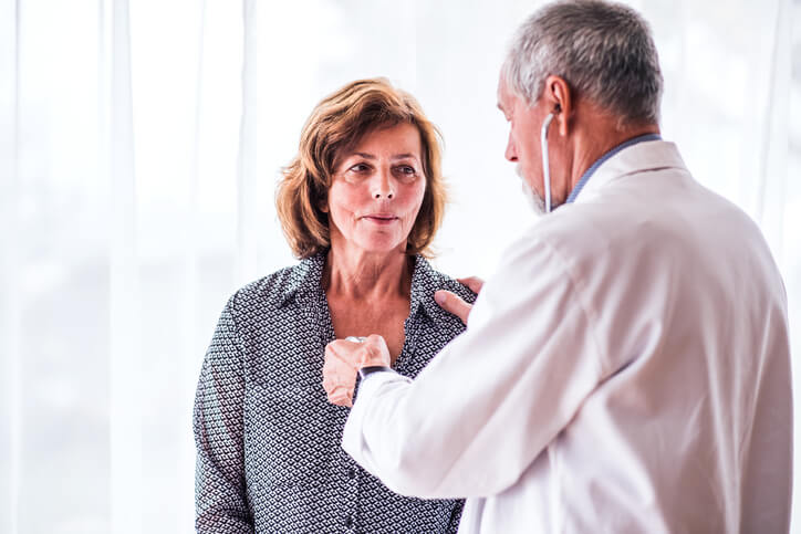 Internal medicine doctor examiming a senior woman in his office