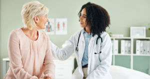 Image of a senior woman and a female primary care physician discussing during a consultation.
