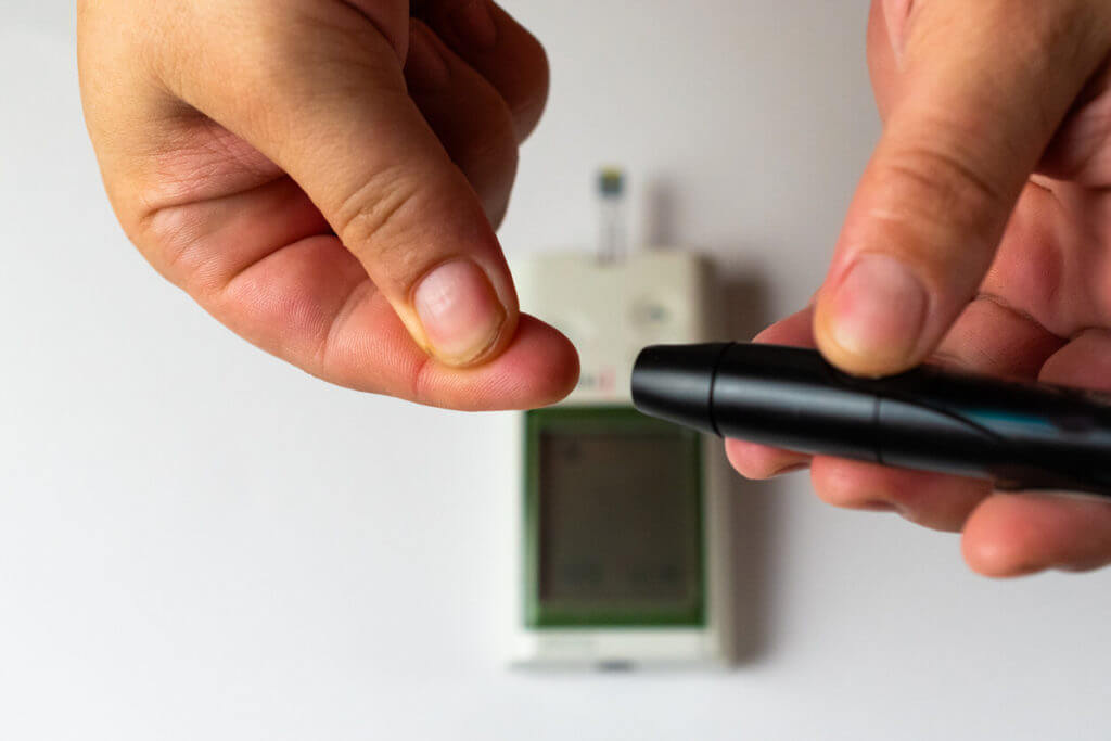 A person performing a blood sugar test to check for Type 1 diabetes.
