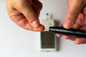 A person performing a blood sugar test to check for Type 1 diabetes.