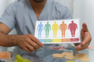 A primary care doctor shows a body mass index chart to a patient who needs to lose weight.